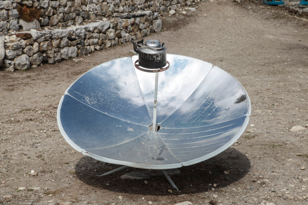 warming,the,teapot,in,a,solar,cooker.,ecology,concept.,renewable